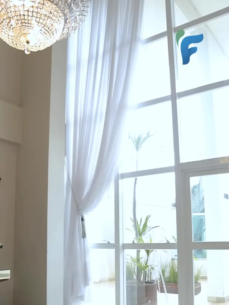 Cortinas claras higienizadas em ambiente amplo com pé direito alto