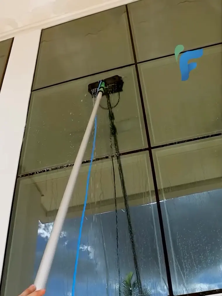 Limpeza de vidro em altura com equipamento de alcance em fachada corporativa